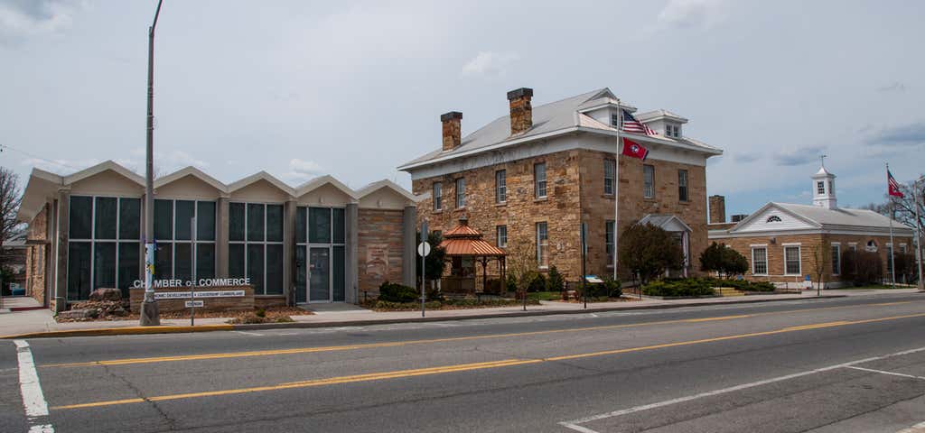 Crossville Chamber of Commerce building on Main Street, beside a historic stone building